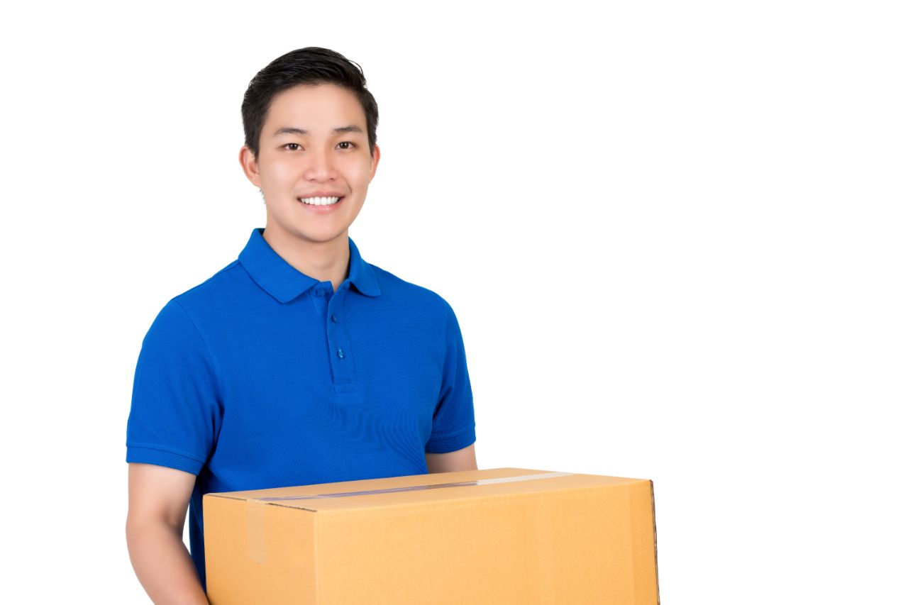 A man in a blue polo shirt holding a box